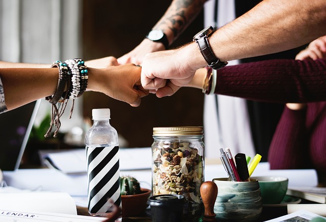 People engaged in like a fourway fist bump as a team.